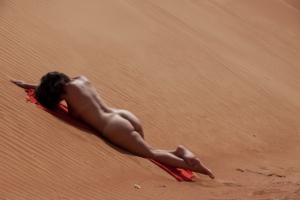 nude woman on sand dune in desert