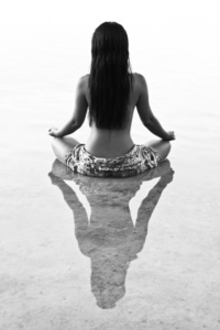 woman meditating, sitting in water
