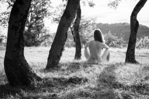 nude woman gazing onto forest hills