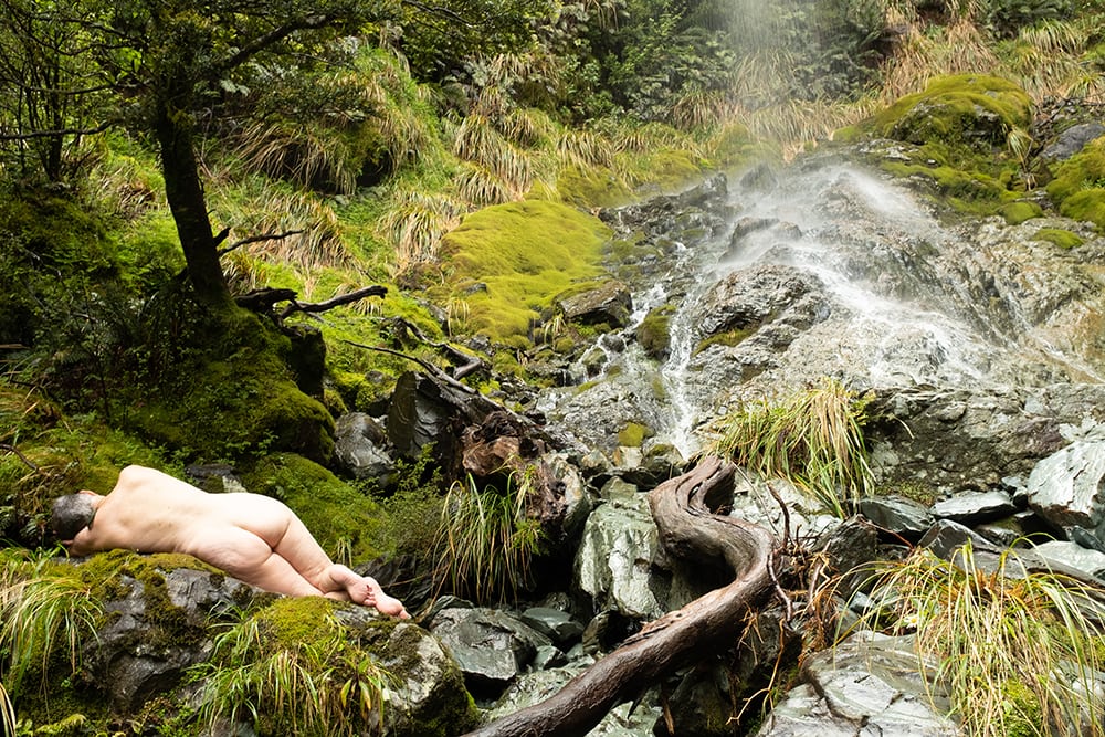 woman laying by waterfall